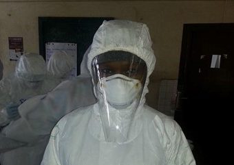 An African woman in full PPE with 'Haja' written on her chest