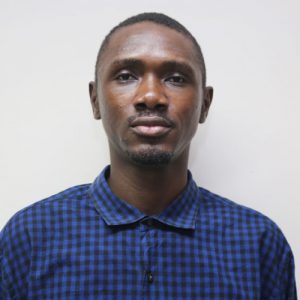 Headshot of a young African man with blue chequered shirt