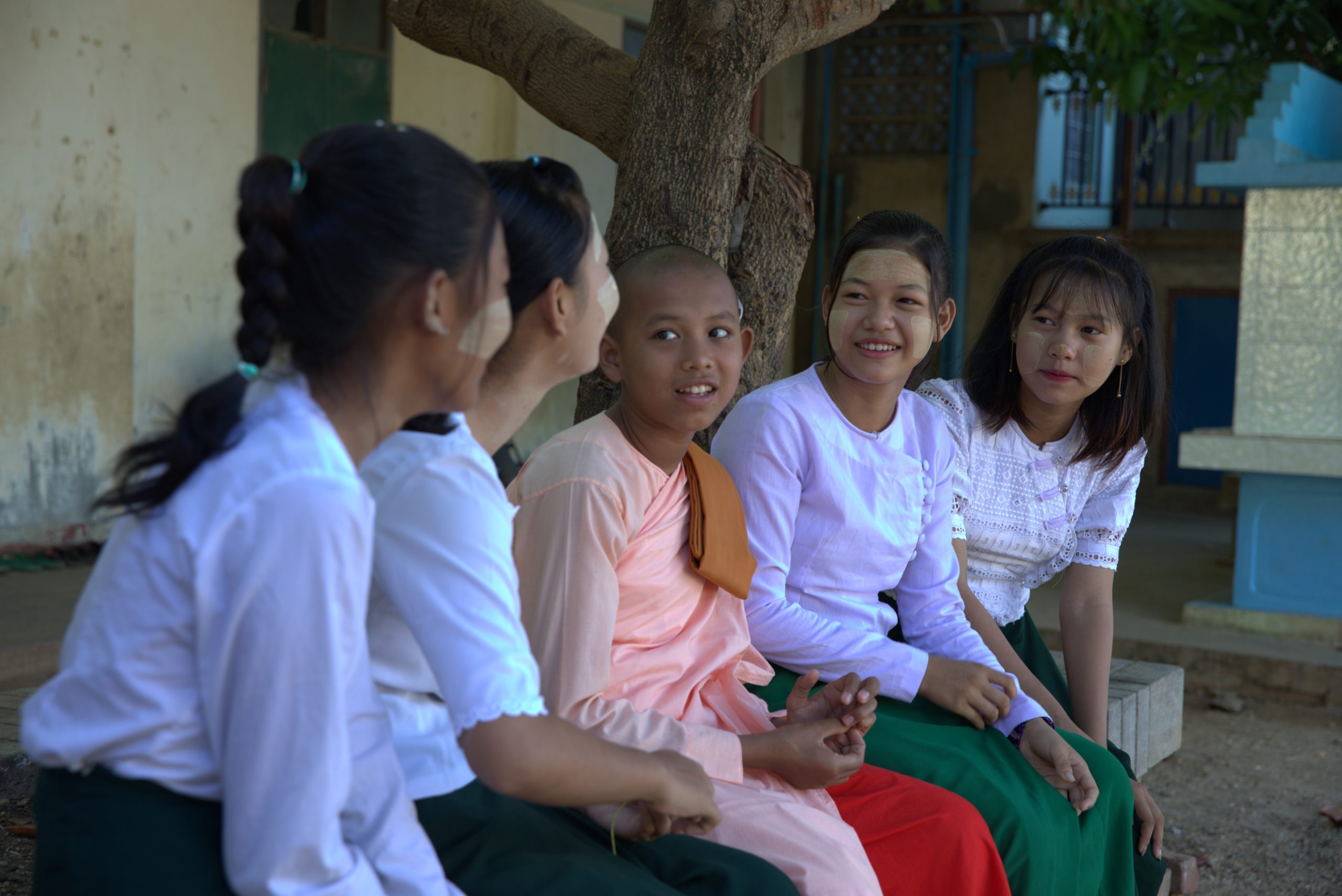 A row of seated smiling young females in Myanmar