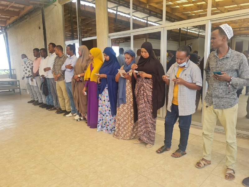 Ethiopian men and woman stand in a line at the start of the power walk