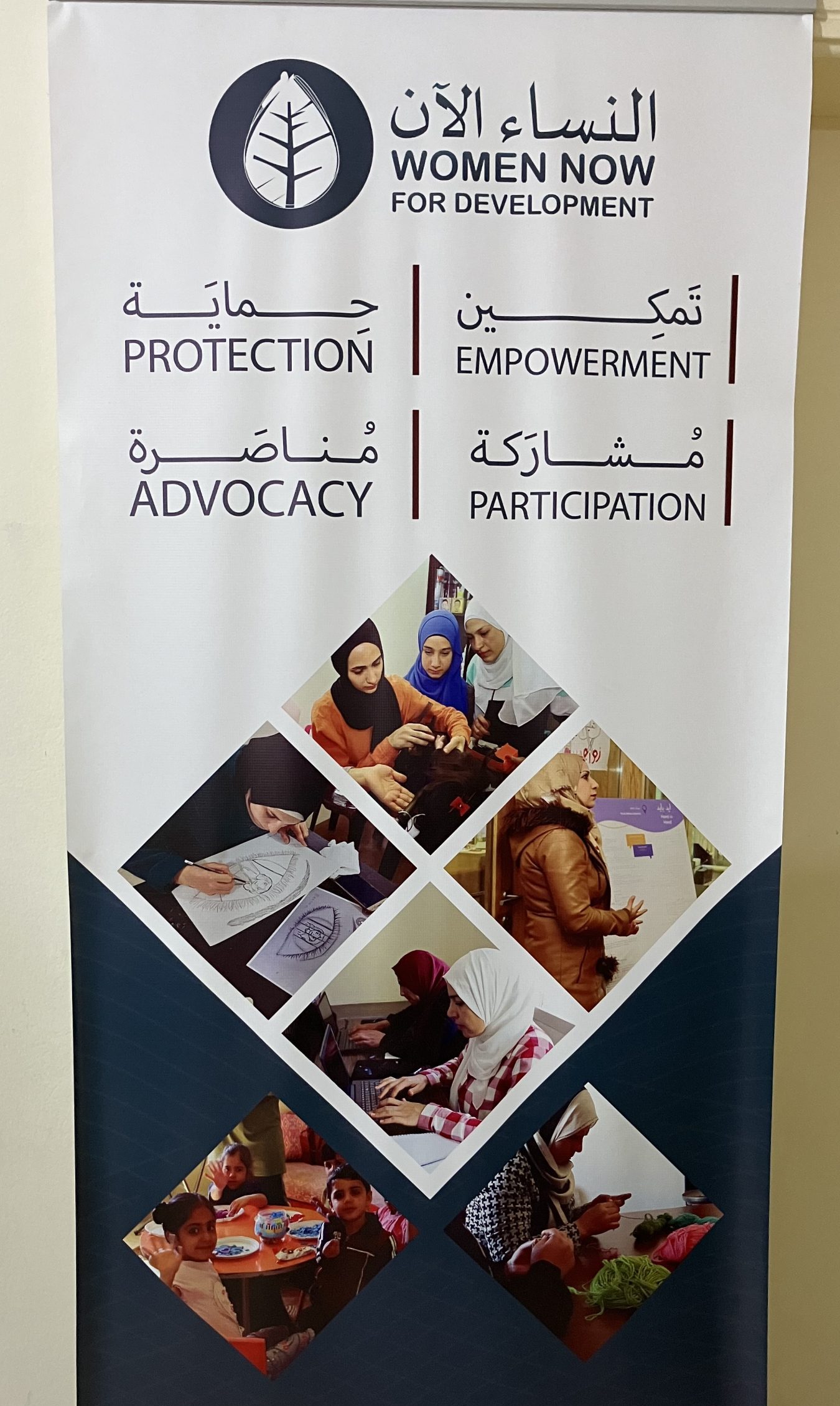 A pop-up banner with the words 'Women Now for Development' and images of Muslim women engaged in activities