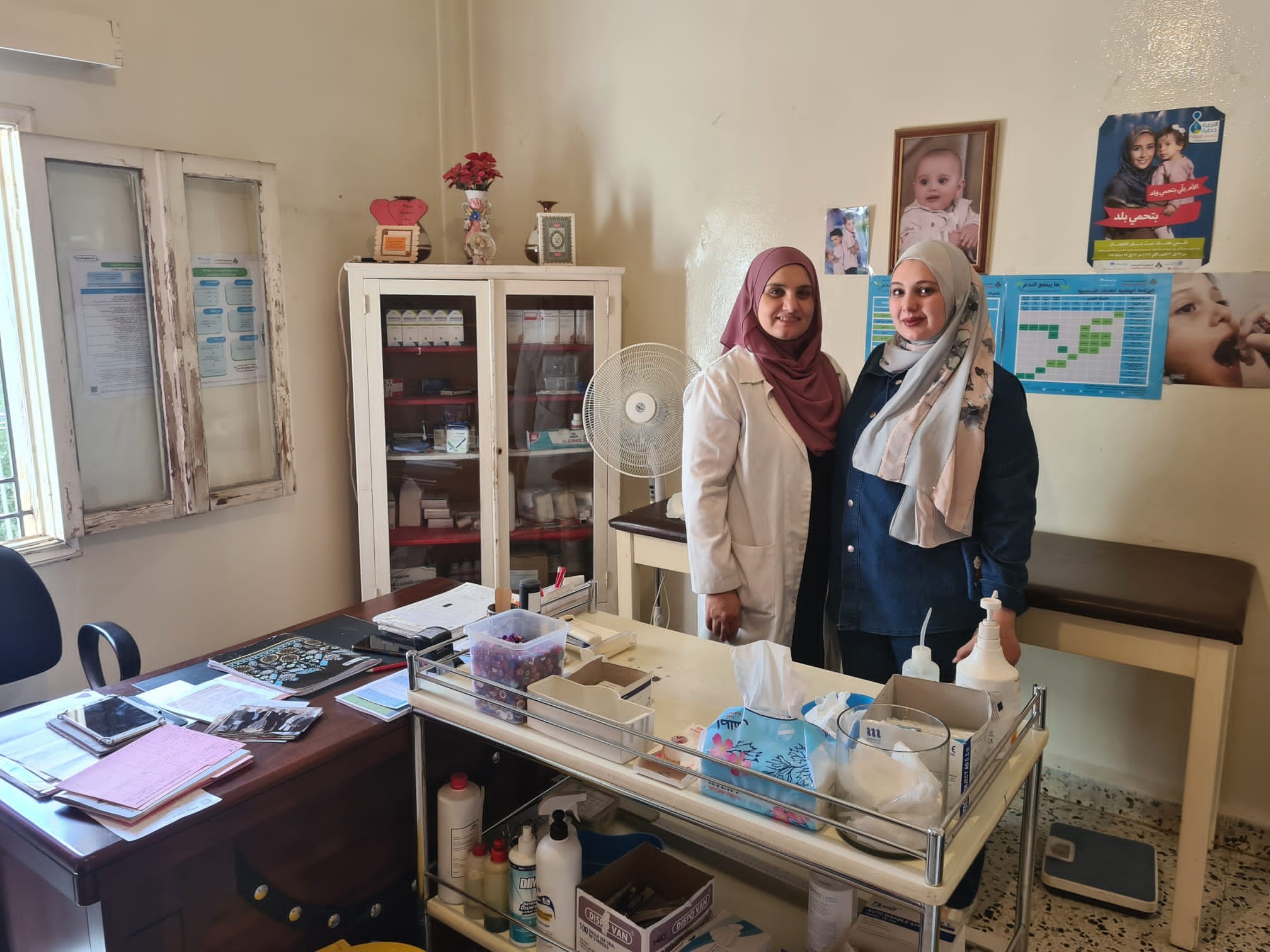 Two female, Syrian medics stand in a consulting room