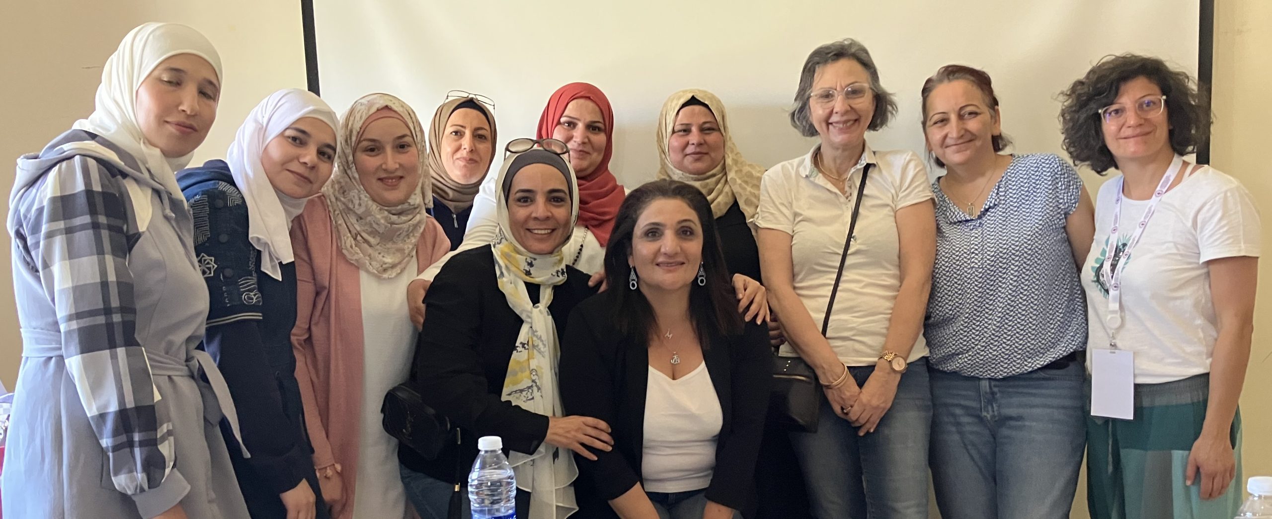 A group of standing and smiling Syrian and Lebanese women