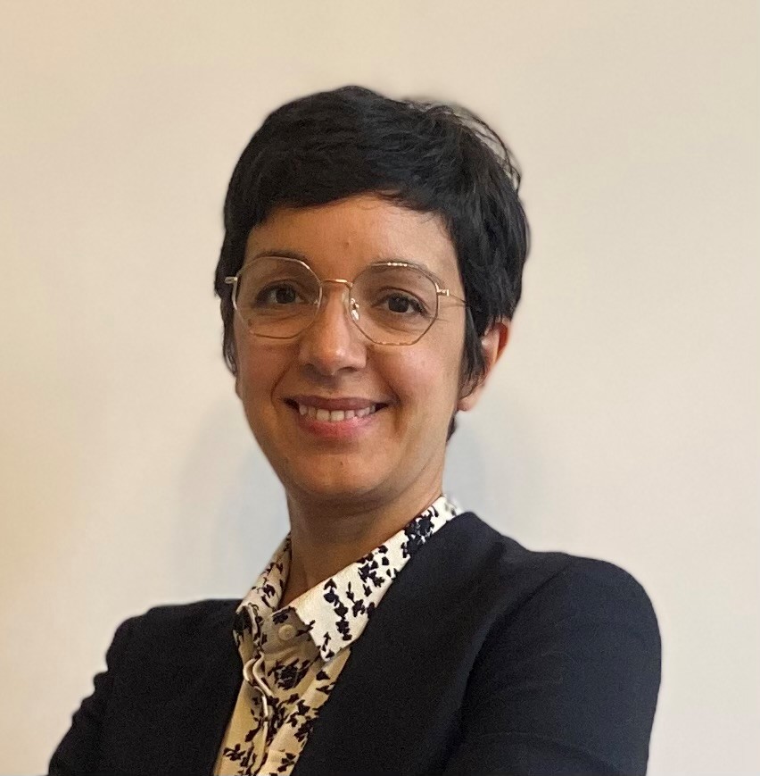 Head shot of a smiling woman with short dark hair and glasses