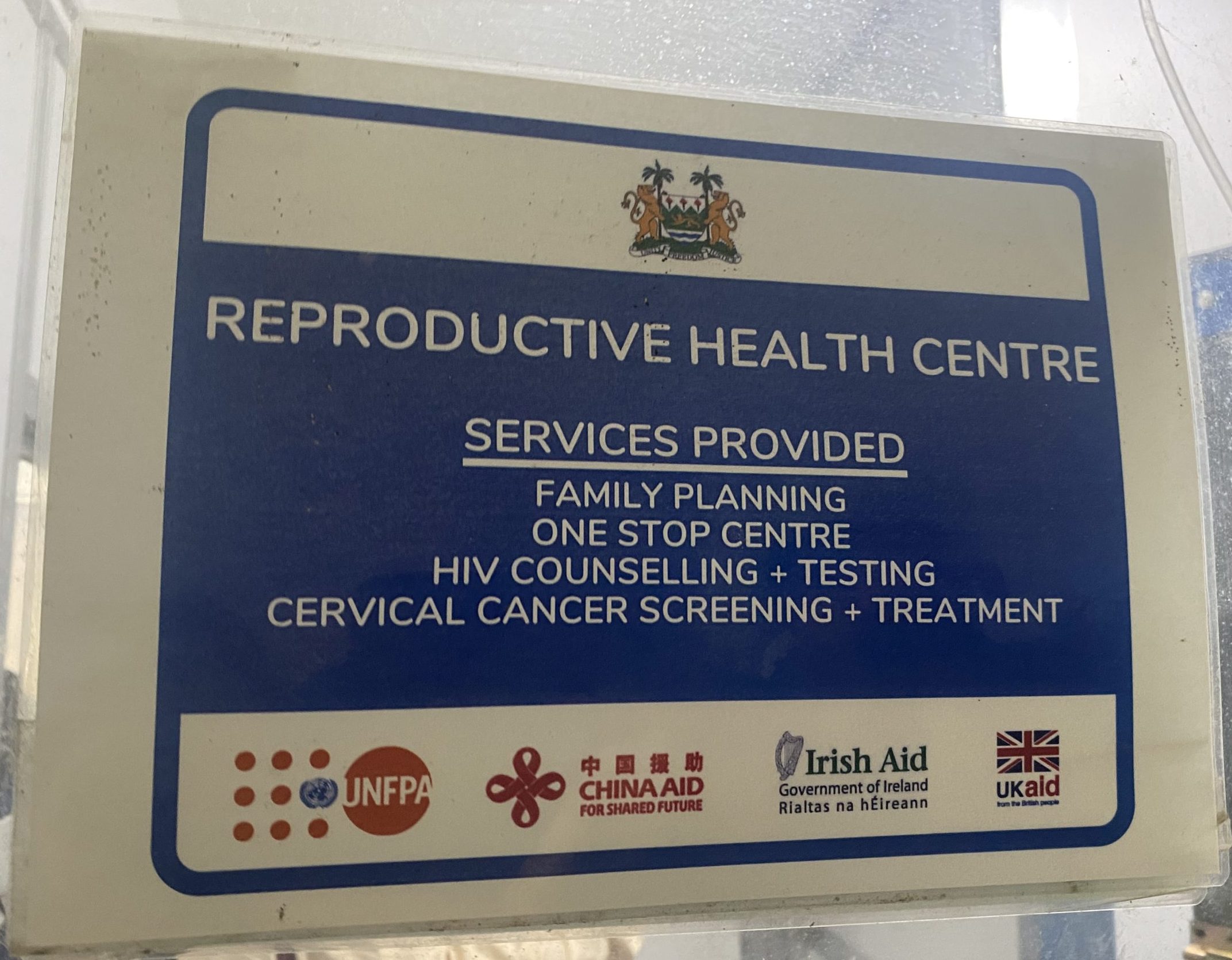A sign on a door for a reproductive health centre, with the logos of 4 international donors