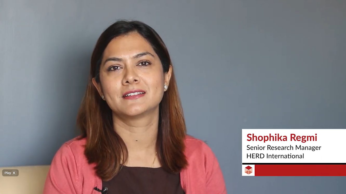 A head shot of a smiling Nepali woman and her name and title